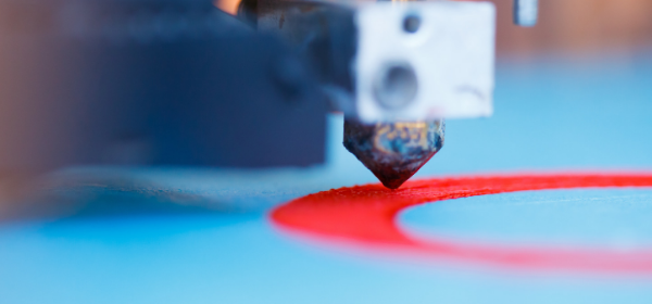 A 3D printer extrudes a layer of material onto platform.